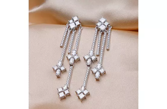 floral and geometric chandelier diamond earrings for rent on satin backdrop