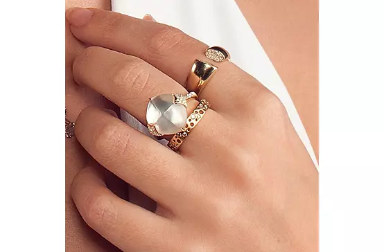 A woman wearing the Mother of Pearl Diamond Ring, paired with two other gold rings