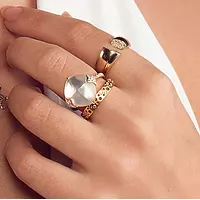 A woman wearing the Mother of Pearl Diamond Ring, paired with two other gold rings