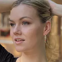A model wearing the Enameled Gold Hoop Earrings.